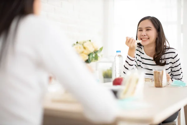 Young Asian  woman sitting separated in restaurant or home  eating food with table protect infection from coronavirus covid-19, new normal restaurant and social distancing concept.