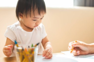 Şirin Asyalı küçük kız, çocuk için sanat ve eğitim kavramını mutluluk dolu bir şekilde renklendiriyor. Kapalı çocuk alıştırması, evde eğitim için para ödemek. Güzel Asyalı kız çizimi.