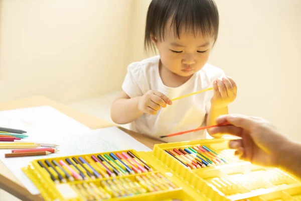 Cute asian little girl is painting the color with fully happiness moment , concept of art and education for kid. closed up kid practice paiting for homeschooling.Lovely asian girl drawing
