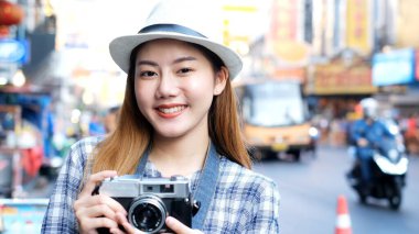 Gezgin Asyalı blogcu kadınlar Bangkok, Tayland 'da seyahat ediyor, cep telefonu kullanan güzel kadınlar vlog yapıyor ve sosyal medyada yaşıyorlar. Kadın turist, Tayland tapınağında seyahat ederken akıllı telefonla video görüşmesi yapıyor. 