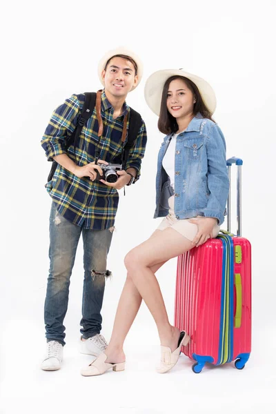 Traveler asian couple with backpack and suitcase standing isolated over white background.Couple Asian  going to summer vacation.People, active lifestyle, relaxation and joy concept.Happy couple is ready to travel, sitting on luggage