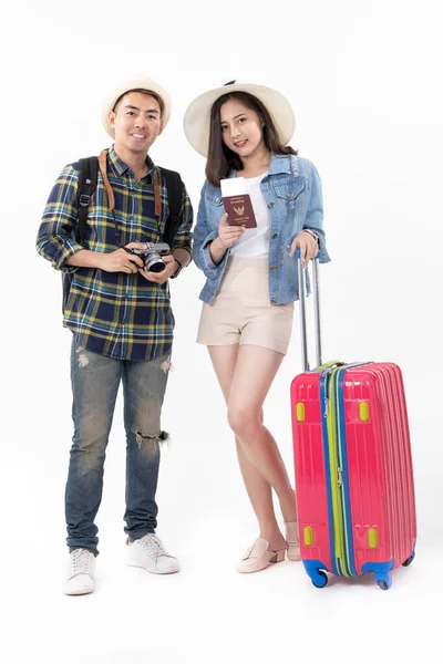 Traveler asian couple with backpack and suitcase standing isolated over white background.Couple Asian  going to summer vacation.People, active lifestyle, relaxation and joy concept.Happy couple is ready to travel, sitting on luggage