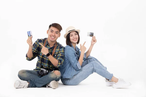 Traveler asian couple with backpack and suitcase standing isolated over white background.Couple Asian  going to summer vacation.People, active lifestyle, relaxation and joy concept.Travel trip funny Credit card on holiday.