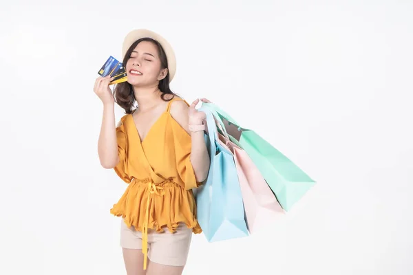 亚洲漂亮的年轻女子坐在白皙的背景上 她笑着高兴地买购物袋 她漂亮可爱迷人的光芒 朋友很高兴有时间购物 — 图库照片