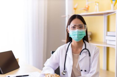 Tıp ve sağlık hizmetleri kavramı. Hastanede yatan Asyalı doktor kadın. Doktor ya da hemşire koruma maskesi takıyor. Enfeksiyonluları kontrol ve tedavi ediyor. .