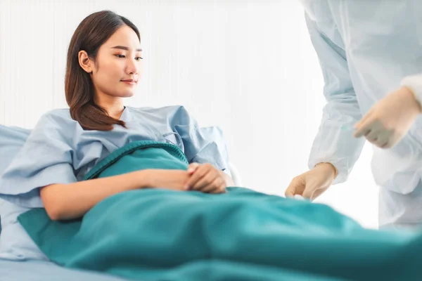 Tıp ve sağlık hizmetleri kavramı. Asyalı doktor hasta kadını hastaneye götürüyor. Doktor ya da hemşire koruma maskesi takıyor. Enfeksiyonu kontrol ediyor. .