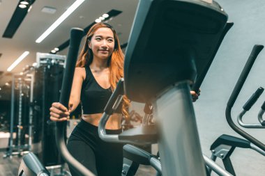 Egzersiz yapan kaslı Asyalı genç bir kadın. Sportif kız spor salonunda ağırlık kaldırıyor..