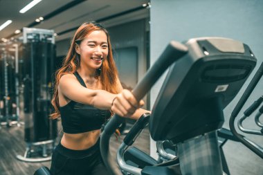 Egzersiz yapan kaslı Asyalı genç bir kadın. Sportif kız spor salonunda ağırlık kaldırıyor..