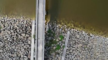 Sakin su ve kırsal manzaralı baraj gölü içinde küçük bir köprü.