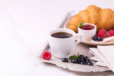 Bir fincan sıcak kahve, kruvasan, ekose ve kitap masada. Eğitim kavramı. Seçici odak