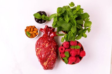 Sağlıklı gıda ve kalp modeli. Fındık ve çilek. Tıbbi soyut kavram