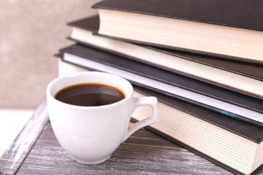 Bir fincan sıcak kahve, ekose ve kitap masada. Eğitim kavramı. Seçici odak