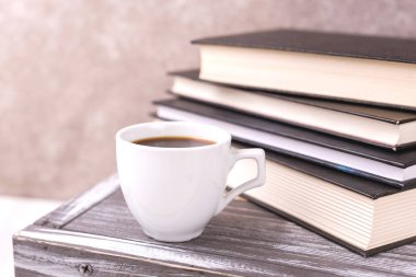 Bir fincan sıcak kahve, ekose ve kitap masada. Eğitim kavramı. Seçici odak