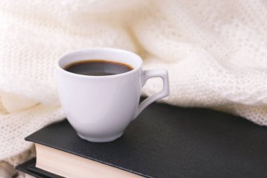 Bir fincan sıcak kahve, ekose ve kitap masada. Eğitim kavramı. Seçici odak