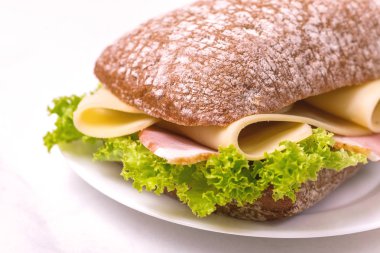 Jambon, peynir ve marul, kahvaltı için kahve Chiabatta sandviç. Seçici odak