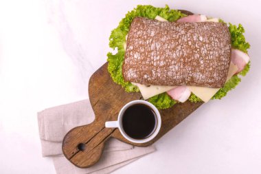 Jambon, peynir ve marul, kahvaltı için kahve Chiabatta sandviç. Seçici odak