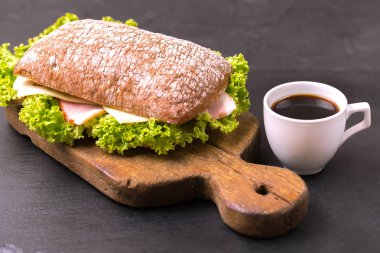 Jambon, peynir ve marul, kahvaltı için kahve Chiabatta sandviç. Seçici odak