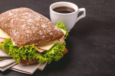 Jambon, peynir ve marul, kahvaltı için kahve Chiabatta sandviç. Seçici odak