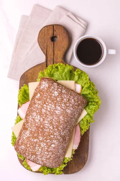Jambon, peynir ve marul, kahvaltı için kahve Chiabatta sandviç. Seçici odak