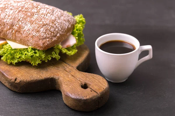 Jambon, peynir ve marul, kahvaltı için kahve Chiabatta sandviç. Seçici odak