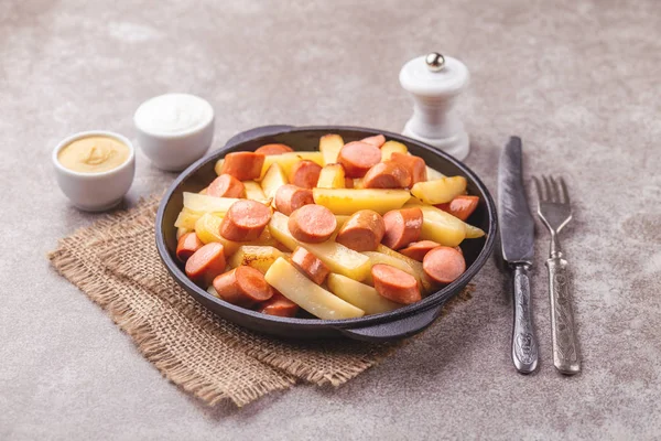 Geleneksel ev yapımı Perulu Salchipapa patates kızartması mayonez, ketçap ve hardal sos ile. Sosis ile kızarmış patates. Fastfood
