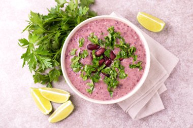 Geleneksel ev yapımı Meksikalı kırmızı fasulye püresi çorba, limon, maydanoz ve kırmızı biber biber. Sıcak ve baharatlı vejetaryen yemek.