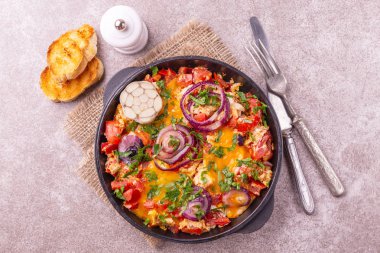 Bir tavada ekmek tost ile Shakshuka. Orta Doğu ve Yahudi geleneksel yemekleri. Domates, biber, sarımsak, soğan, sebze ve otlar ile kızarmış yumurta.