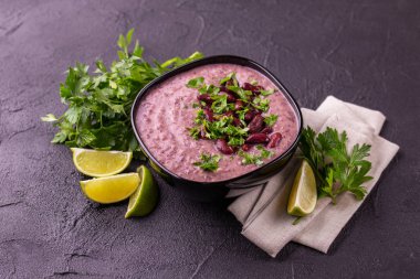 Geleneksel ev yapımı Meksikalı kırmızı fasulye püresi çorba, limon, maydanoz ve kırmızı biber biber. Sıcak ve baharatlı vejetaryen yemek.