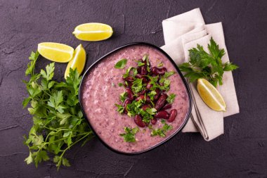 Geleneksel ev yapımı Meksikalı kırmızı fasulye püresi çorba, limon, maydanoz ve kırmızı biber biber. Sıcak ve baharatlı vejetaryen yemek.