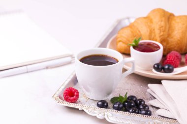 Bir fincan sıcak kahve, kruvasan, ekose ve kitap masada. Eğitim kavramı. Seçici odak