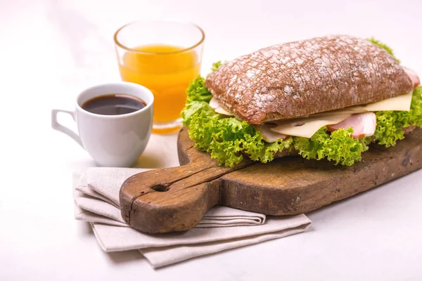 Panino Alla Chiabatta Con Prosciutto Formaggio Lattuga Caffè Succo Arancia — Foto Stock