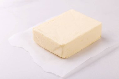 Beyaz ahşap zemin üzerine tereyağı sopa. Kesme tahtası, süt ve süt ürünleri