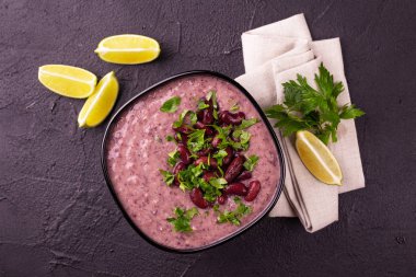 Geleneksel ev yapımı Meksikalı kırmızı fasulye püresi çorba, limon, maydanoz ve kırmızı biber biber. Sıcak ve baharatlı vejetaryen yemek.