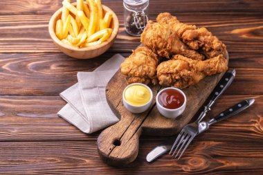 Bacak ve patates kızartması gevrek ve baharatlı tavuk patates kızartması sosları ile. Hızlı ve abur cubur kavramı. Üstten görünüm, boşaltmak