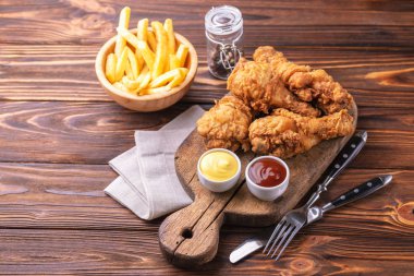 Bacak ve patates kızartması gevrek ve baharatlı tavuk patates kızartması sosları ile. Hızlı ve abur cubur kavramı. Üstten görünüm, boşaltmak