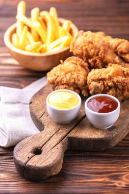 Bacak ve patates kızartması gevrek ve baharatlı tavuk patates kızartması sosları ile. Hızlı ve abur cubur kavramı. Üstten görünüm, boşaltmak