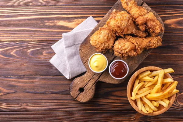 Bacak ve patates kızartması gevrek ve baharatlı tavuk patates kızartması sosları ile. Hızlı ve abur cubur kavramı. Üstten görünüm, boşaltmak