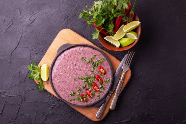 Geleneksel ev yapımı Meksikalı kırmızı fasulye püresi çorba, limon, maydanoz ve kırmızı biber biber. Sıcak ve baharatlı vejetaryen yemek.