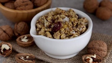 Ev yapımı granola ile fındık ve kuru üzüm gri kayrak zemin üzerine kase. Yatay görünüm. Kopya alanı