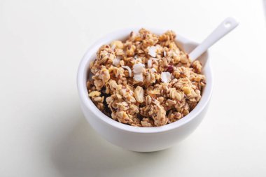 Ev yapımı granola ile fındık ve kuru üzüm beyaz arka plan üzerinde kase. Yatay görünüm. Kopya alanı