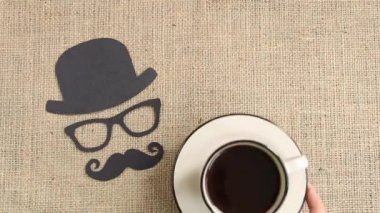 Erkek siluet desenle bıyıkları, gözlük ve şapka ile çuval bezi arka plan üzerinde kahve. Movember kavramı. Prostat kanseri ve erkekler sağlık bilinci. Üstten görünüm