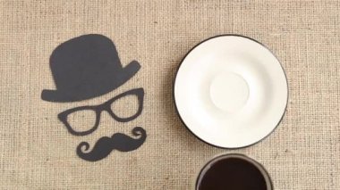 Erkek siluet desenle bıyıkları, gözlük ve şapka ile çuval bezi arka plan üzerinde kahve. Movember kavramı. Prostat kanseri ve erkekler sağlık bilinci. Üstten görünüm