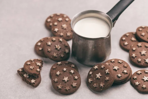 Chocolate cookies with jar of hot milk on the gray slate background. Horizontal view. Cozy evening. Copy space