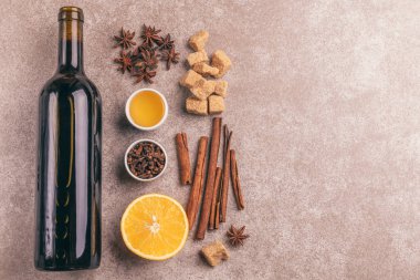 Gri kayrak arka plan üzerinde mulled şarap tarifi Malzemeler. Noel veya içki ısınma kış. Bir şişe şarap, bal, portakal, tarçın, karanfil ve şeker yukarıdan. Kopya alanı