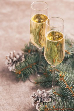 Şampanya Noel ağaç dalları ve koniler kayrak mermer zemin üzerine iki kadehlerin. Yatay görünüm. Kopya alanı.