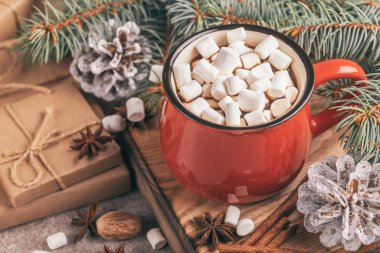 Sıcak kakao ile hatmi ile Noel dekorasyonları ahşap kesme tahtası üzerinde kırmızı fincan. Yatay görünüm. Yakın çekim