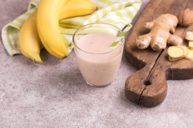 Zencefil ile gri mermer zemin üzerine kağıt payet gözlük ile muz ve badem güler yüzlü. Yatay görünüm. Kopya alanı