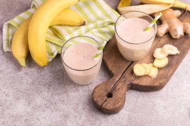 Zencefil ile gri mermer zemin üzerine kağıt payet gözlük ile muz ve badem güler yüzlü. Yatay görünüm. Kopya alanı