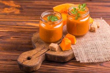 Maydanoz çuval bezi peçete ile eski rustik kesme tahtası üzerinde cam kavanoza Taze kabak güler yüzlü. Ahşap arka plan. Yatay görünüm. Kopya alanı