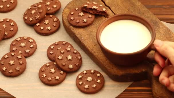 在粘土杯热牛奶在老木切板与新鲜出炉的巧克力饼干在羊皮纸上 水平视图 — 图库视频影像